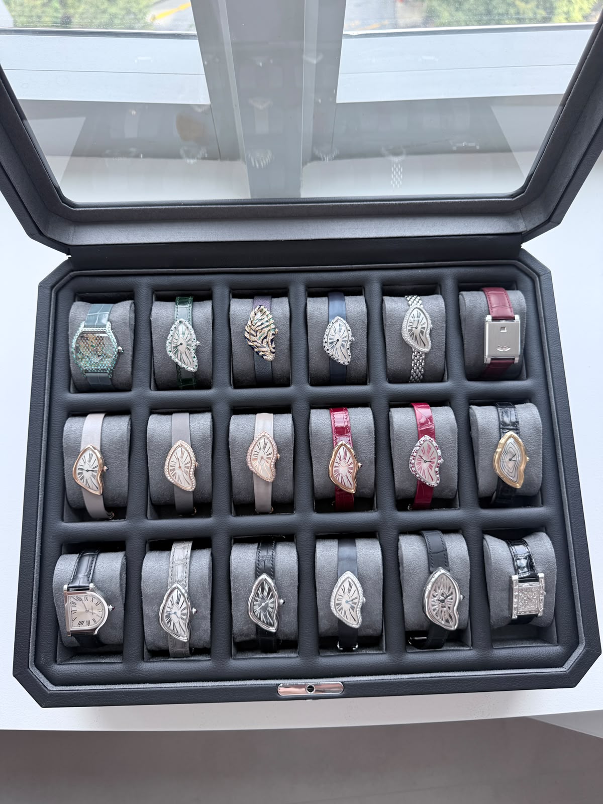 Watch case holding Cartier Crash watches alongside other Cartier pieces