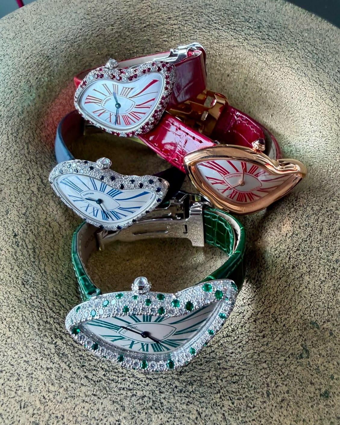 Three Cartier Crash watches spotted with rubies, sapphires and emeralds, with a pink gold Crash with red numerals