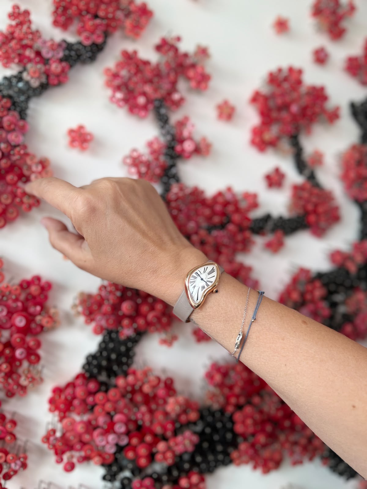 Pink gold Cartier Crash on a grey strap worn on the wrist