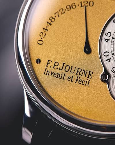 Macro of an F.P. Journe gold dial showing the Invenit et Fecit signature and power-reserve scale