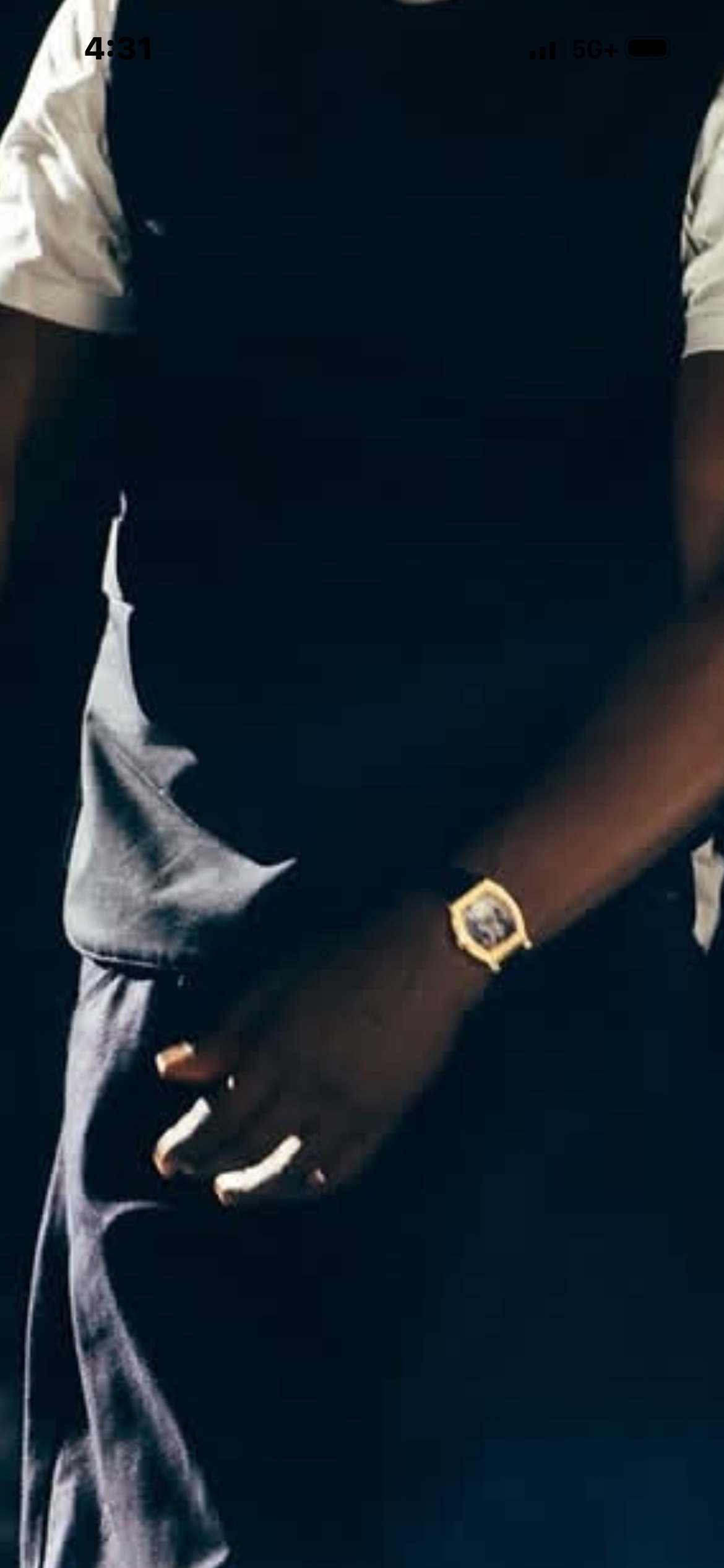 Close-up of a gold tonneau F.P. Journe Vagabondage II on Jay-Z's wrist, hand in pocket